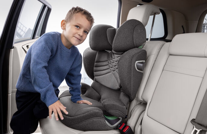 Kind in einem Auto, was sich in einen Solution T i-Fix Kindersitz setzt
